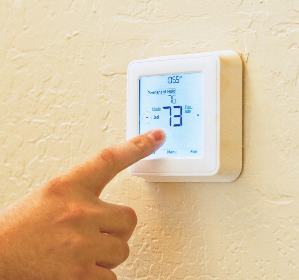 Digital thermostat displaying high temperature, related to AC not cooling house.