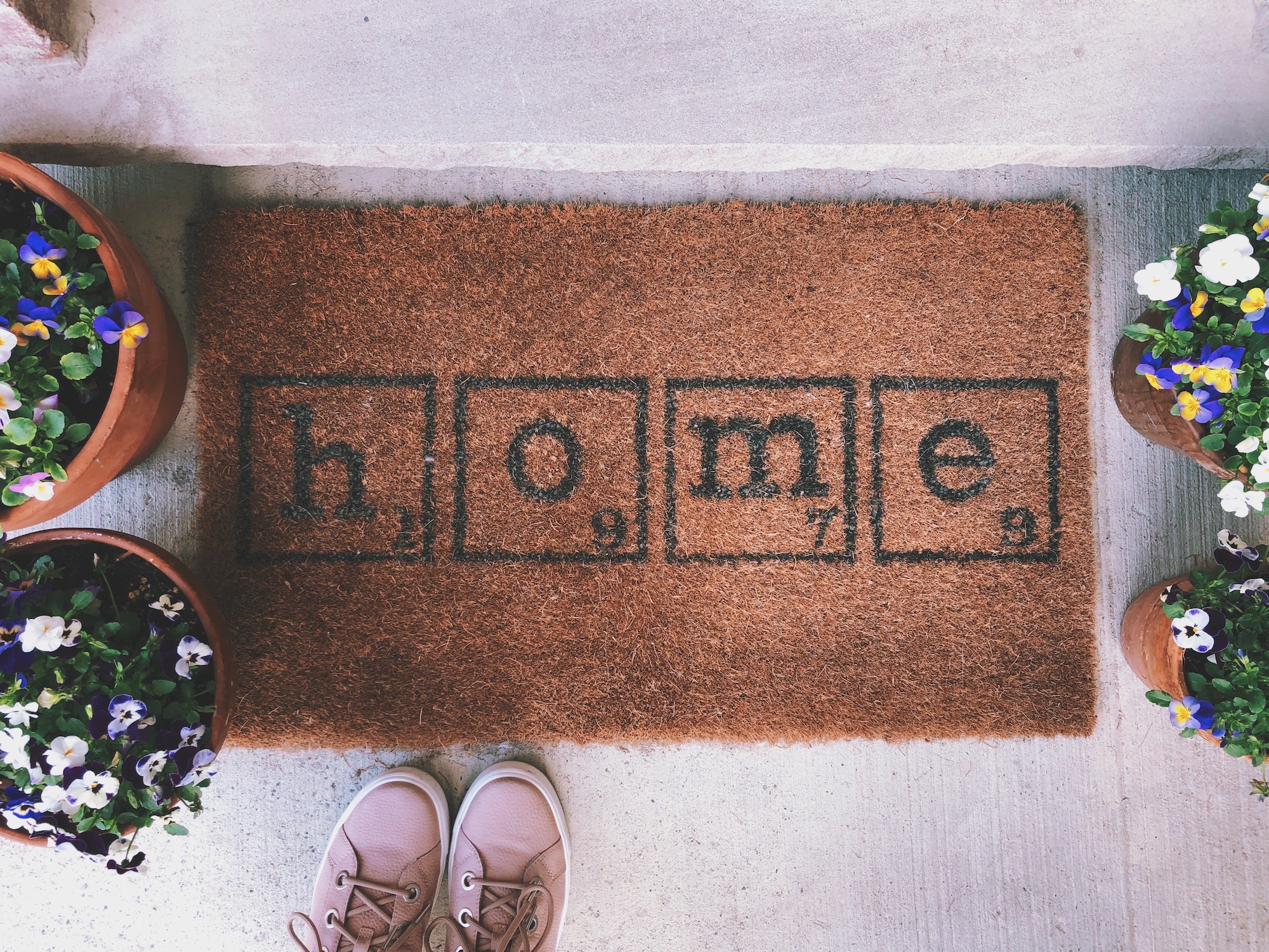 Standing at the front door looking at the doormat saying HOME